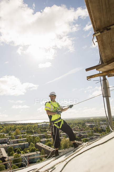 Trabalhador da construção no telhado, foco no fundo — Fotografia de Stock