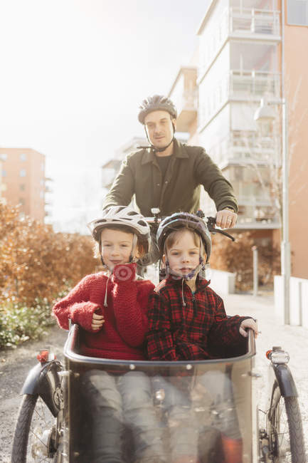 Uomo in bicicletta con i figli, concentrarsi sul primo piano — Foto stock