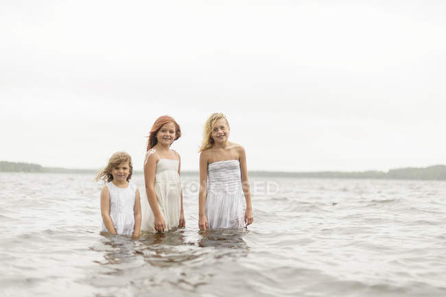 Три девушки, стоящие в воде, избирательный фокус — стоковое фото