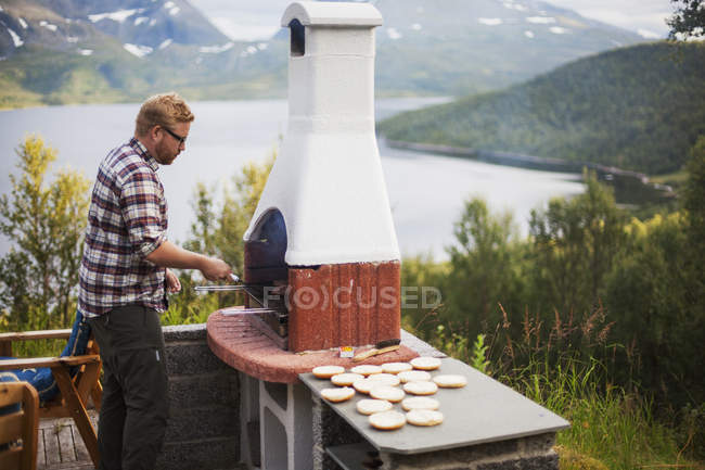 Человек приготовление пищи на открытом камине, избирательный фокус — стоковое фото