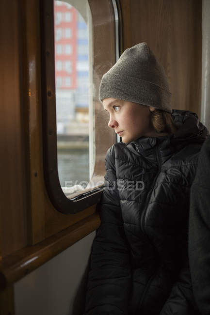 Garçon regardant par la fenêtre du bateau — Photo de stock