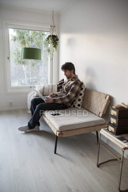 Вид взрослого мужчины средних лет с ноутбука сбоку — стоковое фото