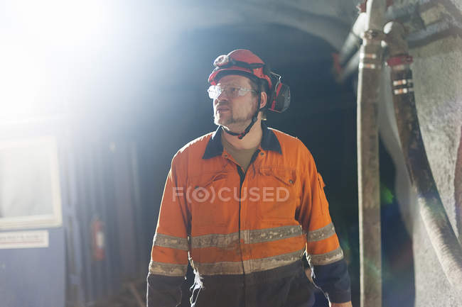 Minatore in indumenti riflettenti che lavora sottoterra — Foto stock