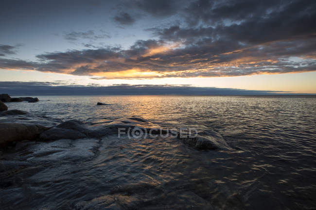 Rochers par la mer au coucher du soleil, Vasterbotten Comté — Photo de stock
