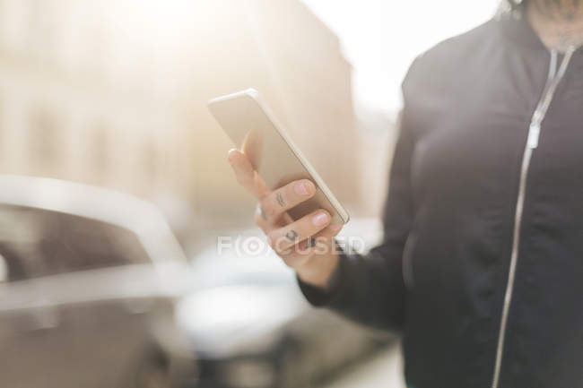 Женщина держит смартфон, сосредоточиться на переднем плане — стоковое фото