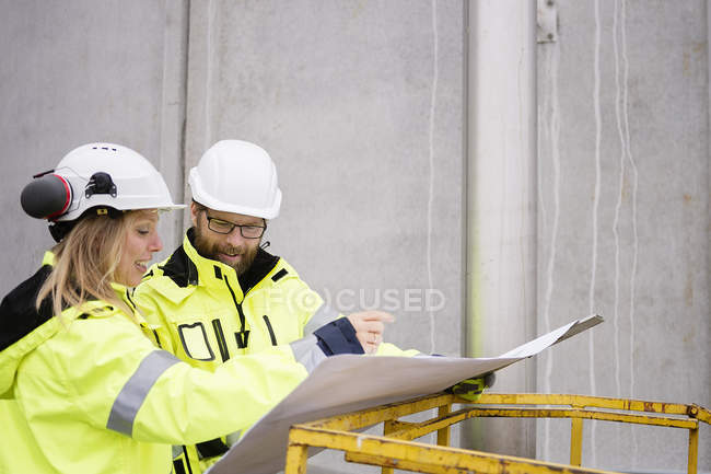 Man and woman discussing blueprints, selective focus — Stock Photo