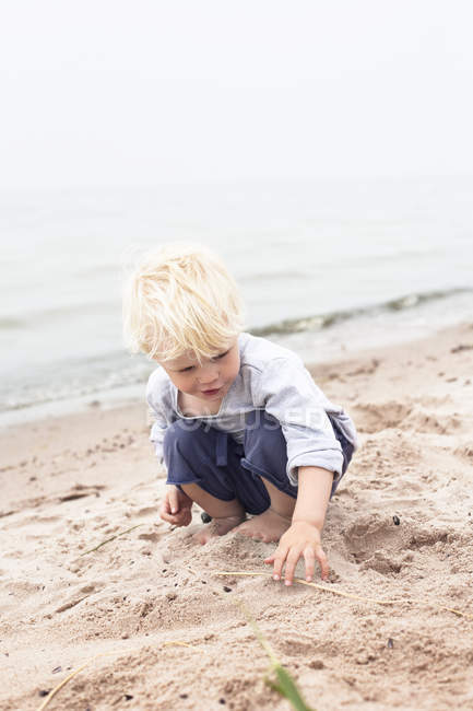 Ragazzo che gioca sulla spiaggia, concentrazione selettiva — Foto stock