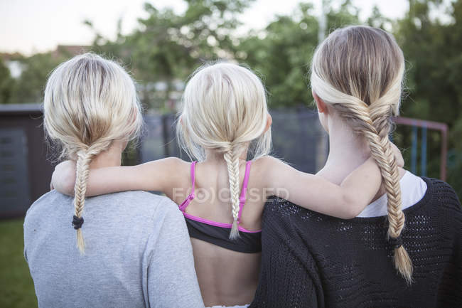 Rear view of mother and children with braided ponytails — Stock Photo