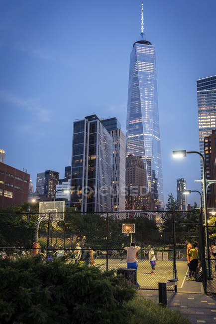 Люди грають в баскетбол, один Всесвітній торговий центр в Нью-Йорку у фоновому режимі — стокове фото