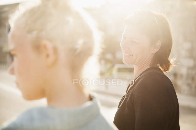 Sorridente mãe e filha olhando para longe, foco em primeiro plano — Fotografia de Stock