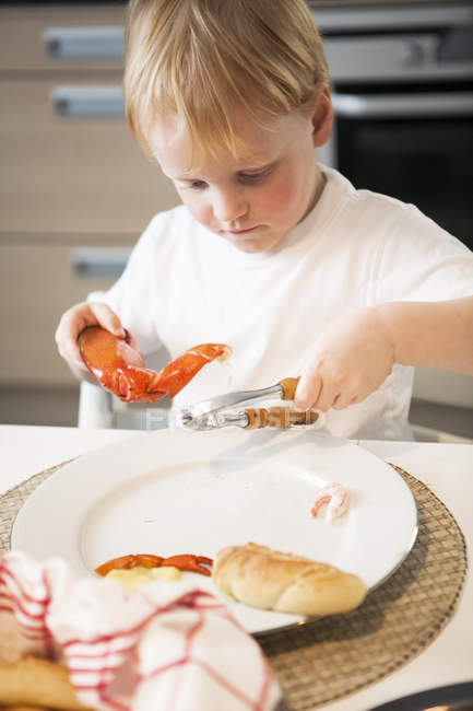 Мальчик ест раков, дифференцированный фокус — стоковое фото