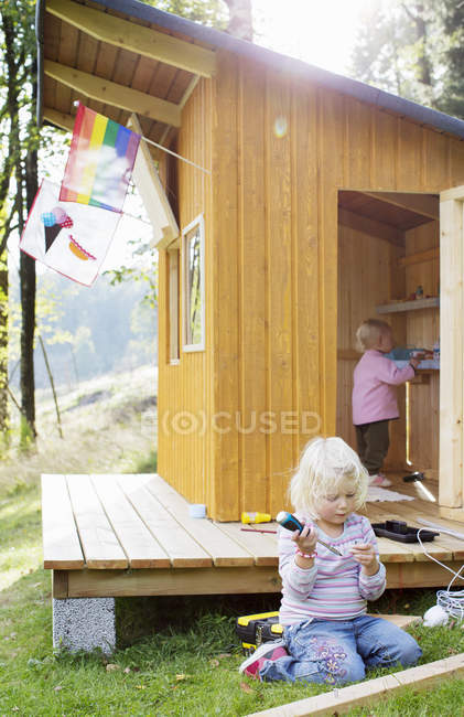 Two girls playing with playhouse, selective focus — Stock Photo