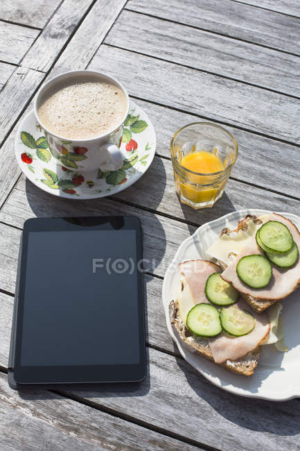 Elevata vista di colazione e tablet digitale su sfondo in legno — Foto stock