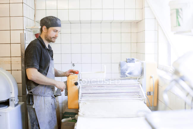Baker with dough for bread in kitchen — Stock Photo