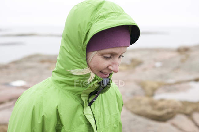 Femme debout sur la plage de rochers, se concentrer sur l'avant-plan — Photo de stock
