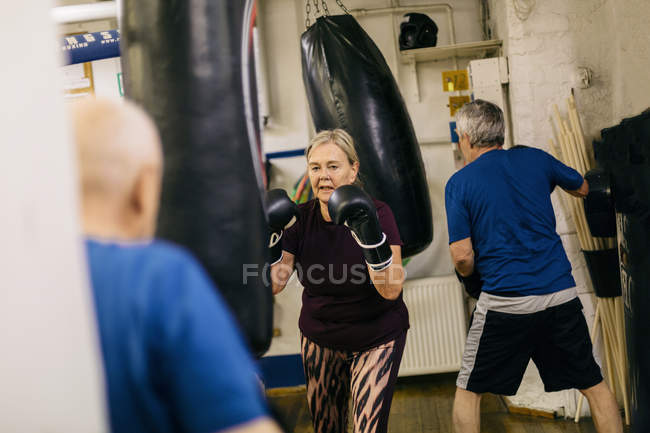 Entrenamiento para mujeres mayores con saco de boxeo, enfoque selectivo - foto de stock
