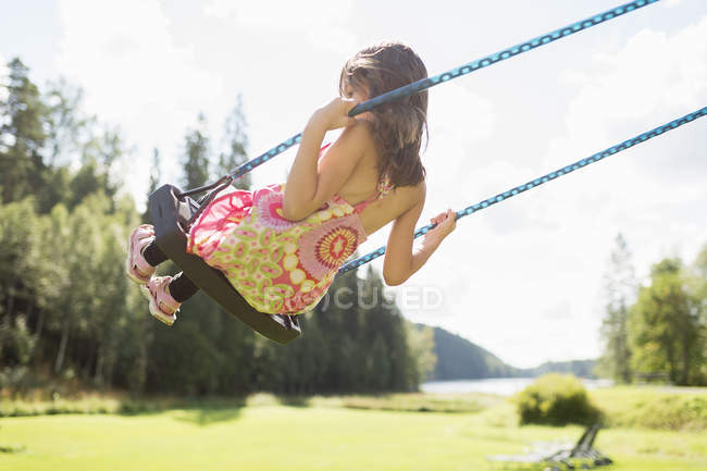 Vue arrière de la fille sur swing, mise au point sélective — Photo de stock