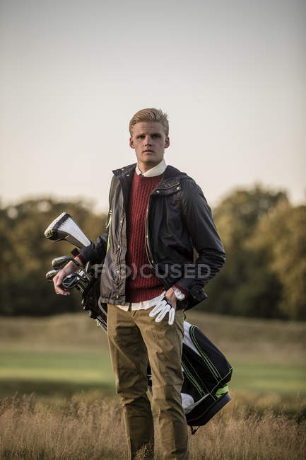 Jeune homme au terrain de golf, se concentrer sur le premier plan — Photo de stock