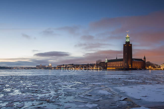 Frozen river and municipal building in background — Stock Photo