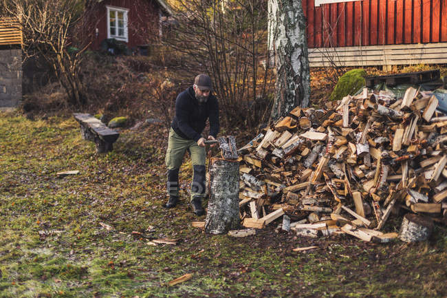 Homem que divide a madeira de fogo, foco seletivo — Fotografia de Stock
