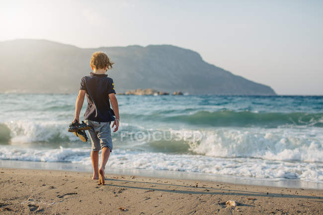 Vista trasera del niño en la playa, enfoque selectivo - foto de stock