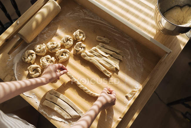 Vue élevée de la femme faisant des petits pains à la cannelle — Photo de stock