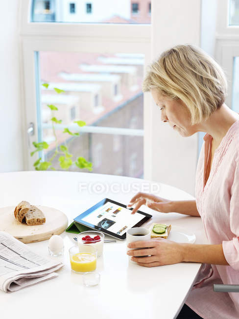 Retrato da mulher usando tablet digital em casa — Fotografia de Stock