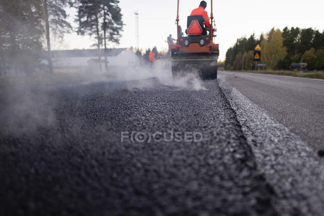 Два ручных рабочих ремонтируют дорогу, избирательная направленность — стоковое фото