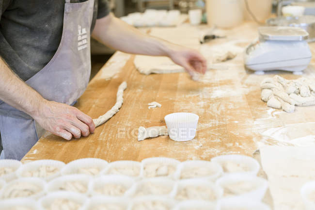 Boulanger faire des rouleaux de pâte, mise au point différentielle — Photo de stock