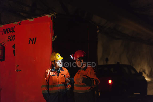 Due uomini in testa miniera ingranaggi, fuoco selettivo — Foto stock