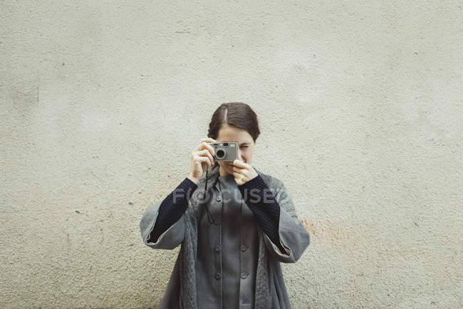 Joven turista con cámara contra pared - foto de stock