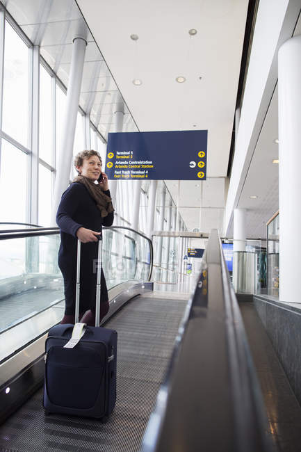 Жінка розмовляє по мобільному телефону в аеропорту — стокове фото