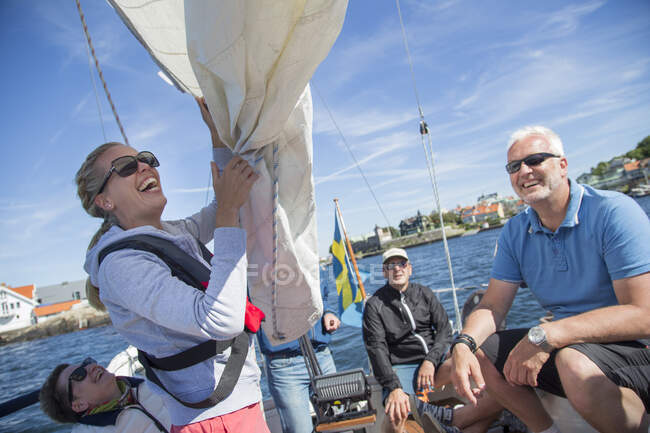 Gente sonriente alegre navegando en yate en el mar - foto de stock