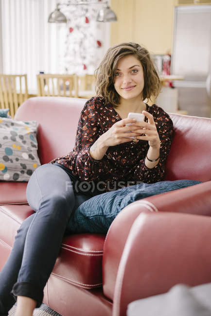 Giovane donna sorridente utilizzando il telefono cellulare — Foto stock