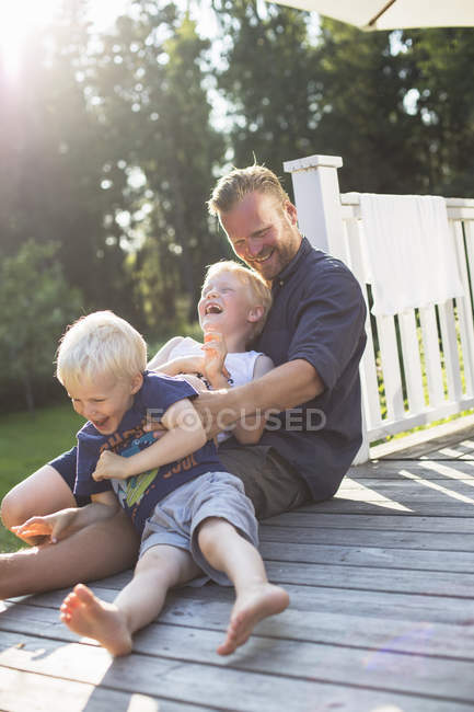 Padre jugando con hijos al aire libre, enfoque selectivo - foto de stock