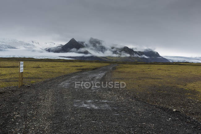 Гравийная дорога под штормовыми облаками в Исландии — стоковое фото