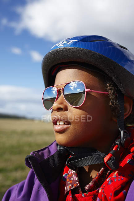 Retrato de niña en casco de ciclismo y gafas de sol - foto de stock