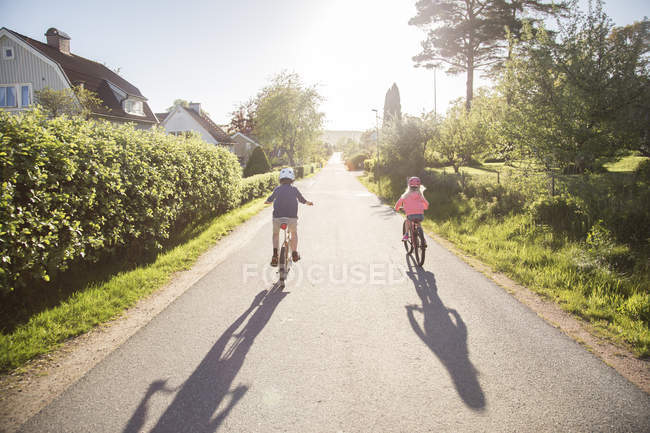 Дети катаются на велосипеде в солнечный день, избирательный фокус — стоковое фото
