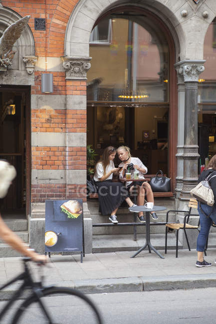 Hermanas sentadas en la cafetería, enfoque selectivo - foto de stock