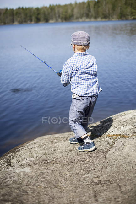 Boy trying to catch fish, differential focus — Stock Photo