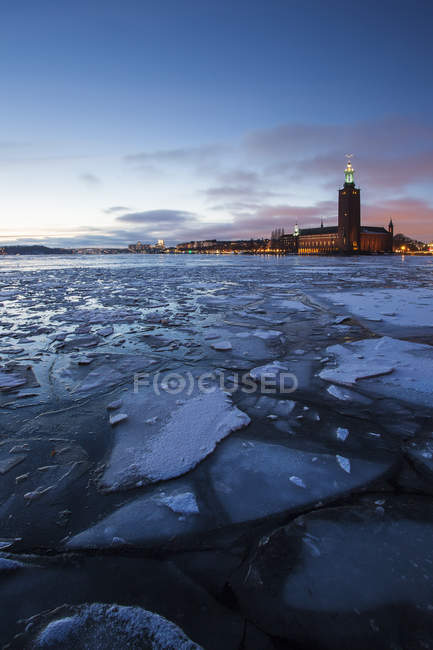 Scenic view of municipal buildings across icy water — Stock Photo