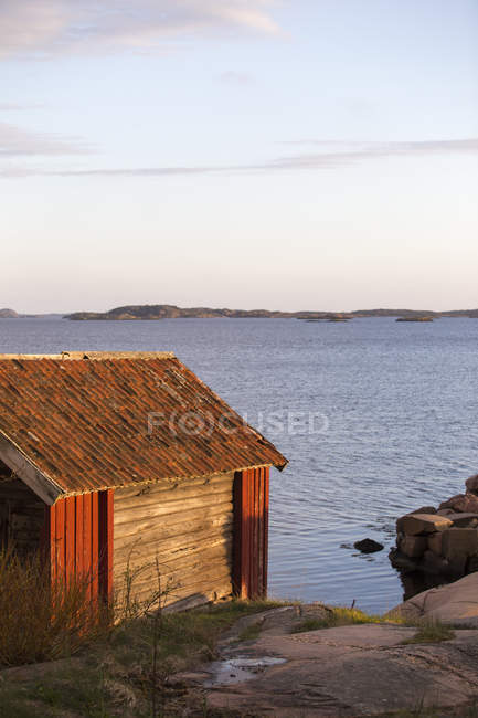 Casa de barcos de madeira na margem do lago, costa oeste sueca — Fotografia de Stock