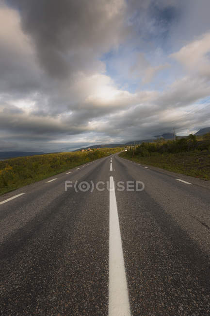 Сільська дорога проти неба з хмар у Швеції — стокове фото