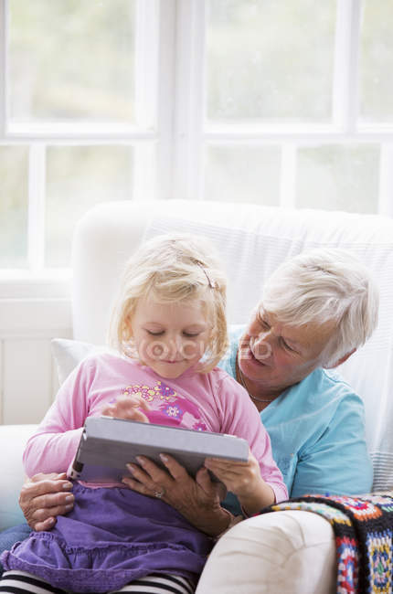 Бабуся і онука використовують цифровий планшет, фокус на передньому плані — стокове фото