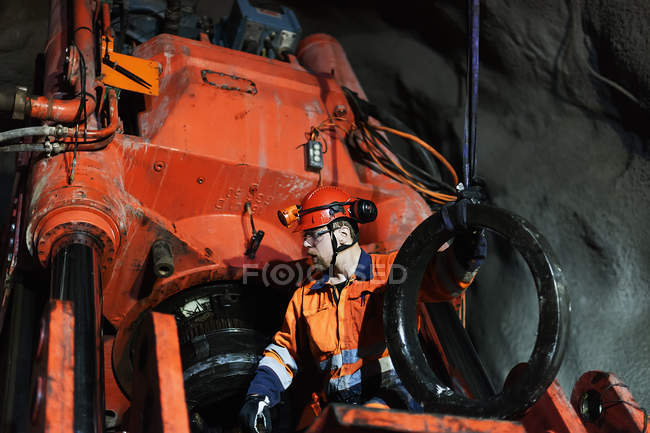 Minero en ropa de trabajo protectora trabajando bajo tierra - foto de stock