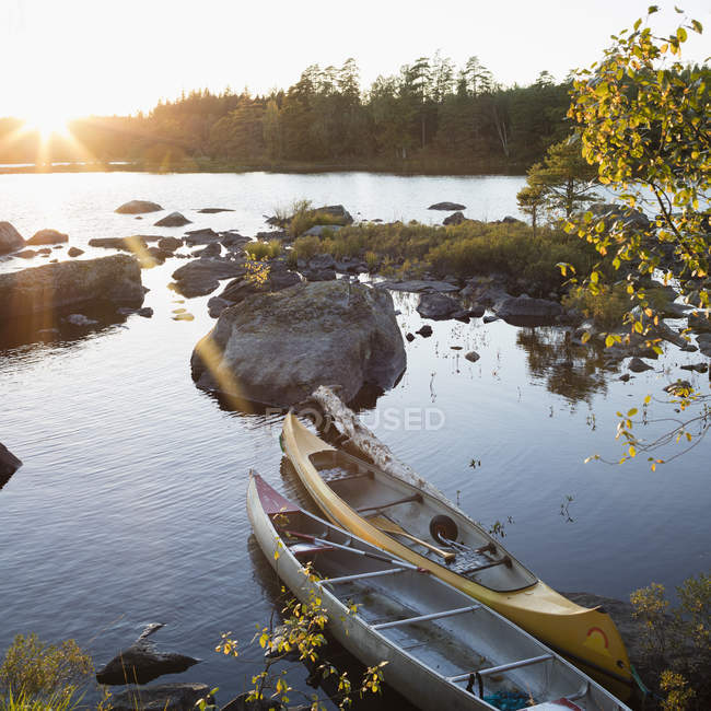 Canoas amarradas en la orilla, reino de Suecia - foto de stock