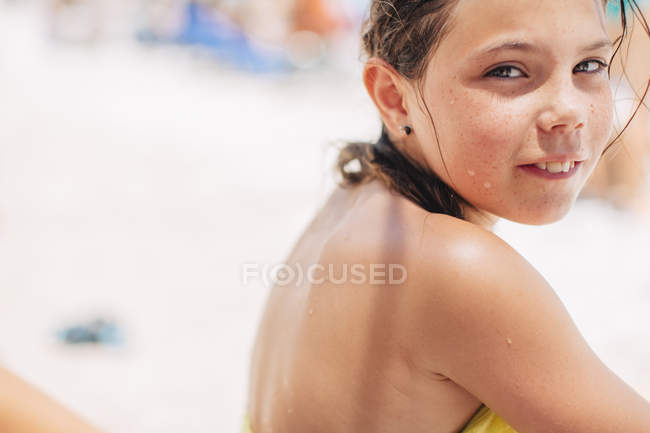 Mädchen in Badebekleidung blickt in die Kamera, Fokus auf den Vordergrund — Stockfoto