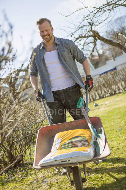 Homem trabalhando no jardim doméstico, foco em primeiro plano — Fotografia de Stock