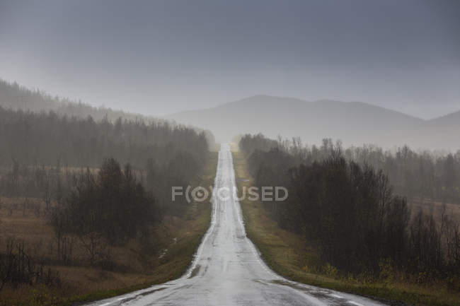 Estrada rural sob nuvens de tempestade na Suécia — Fotografia de Stock