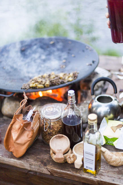 Essen und Gewürze draußen am Lagerfeuer, Fokus auf den Vordergrund — Stockfoto
